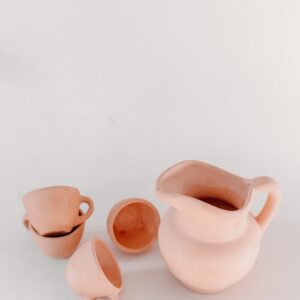 a white table topped with three pink vases